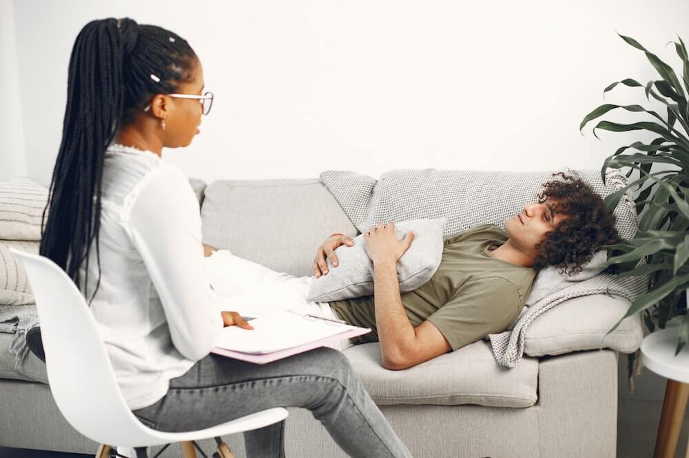 Man-lying-on-chair-talking-hypnotherapist