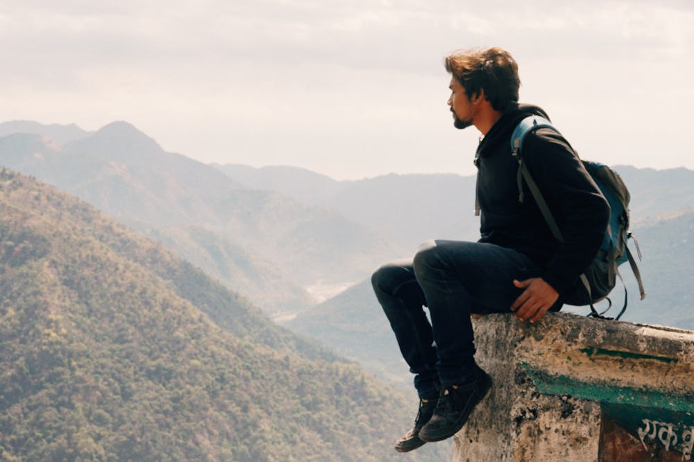 Man-Sitting-Edge-Of-Wall