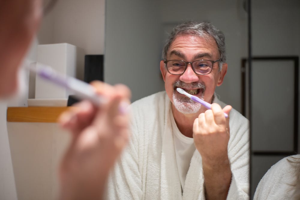 Man-Brushing-Teeth-In-Bathroom