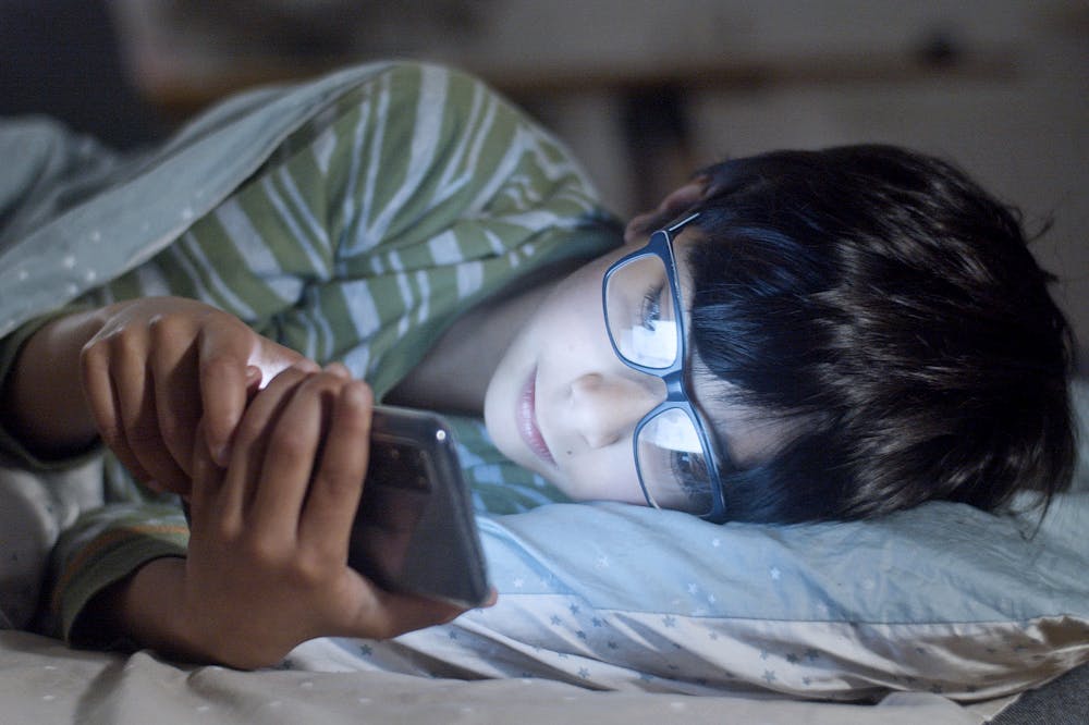 Silent-Retreat-Boy-Scrolling-Phone-in-bed