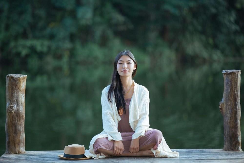 lone-woman-meditating-waterfront