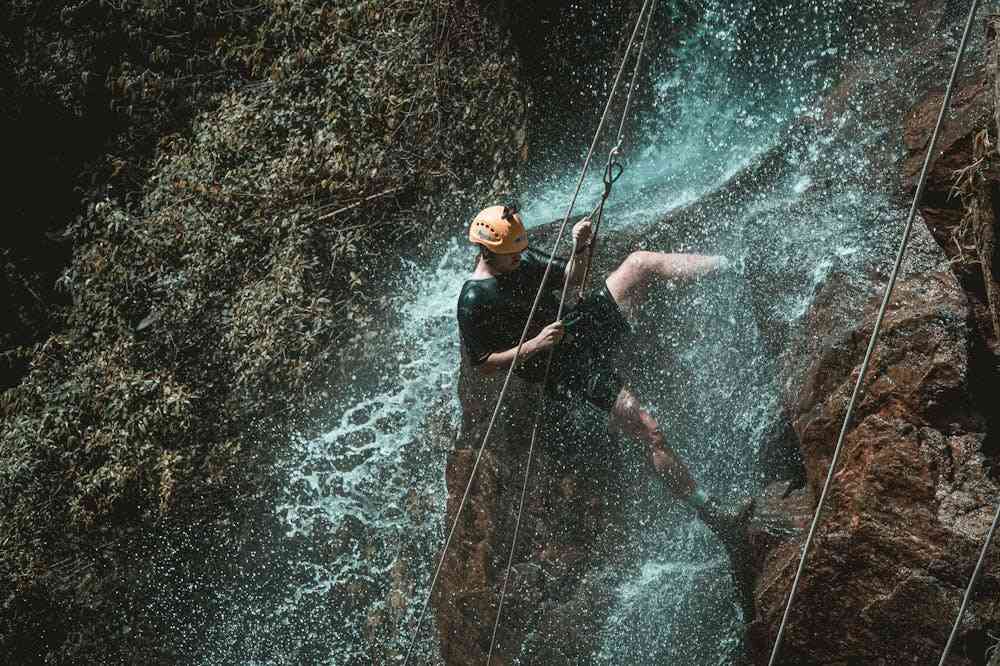 Active-Man-Rappelling-on-Cliff