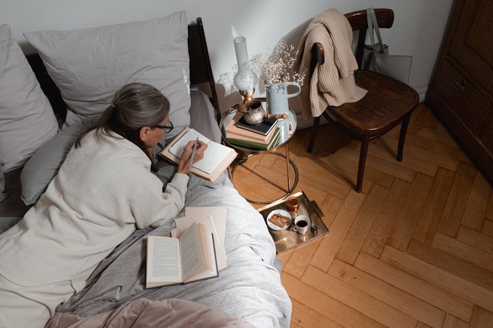 Woman-Writing-Notes-In-Bed