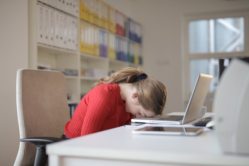 Woman-sitting-with-head-on-laptop