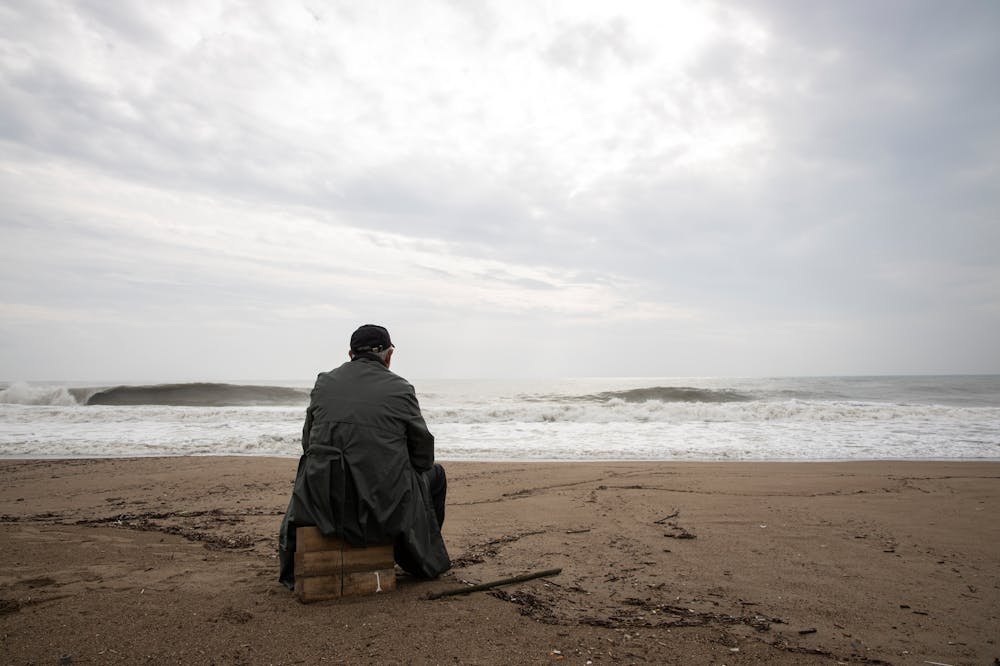 Man-Sitting-By-The-Shore