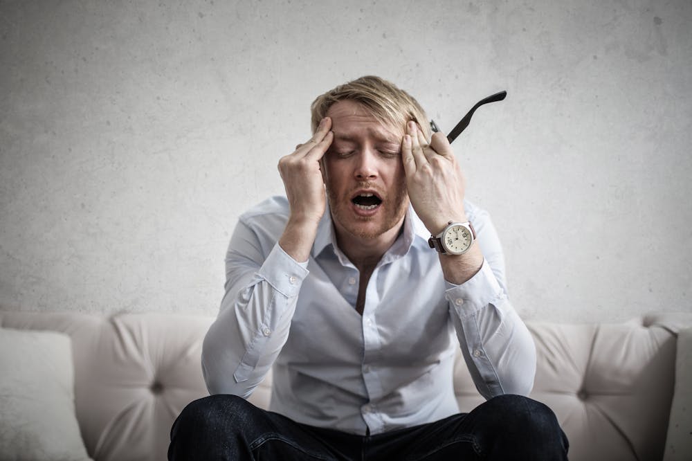 Man-touching-forehead-looking-stressed