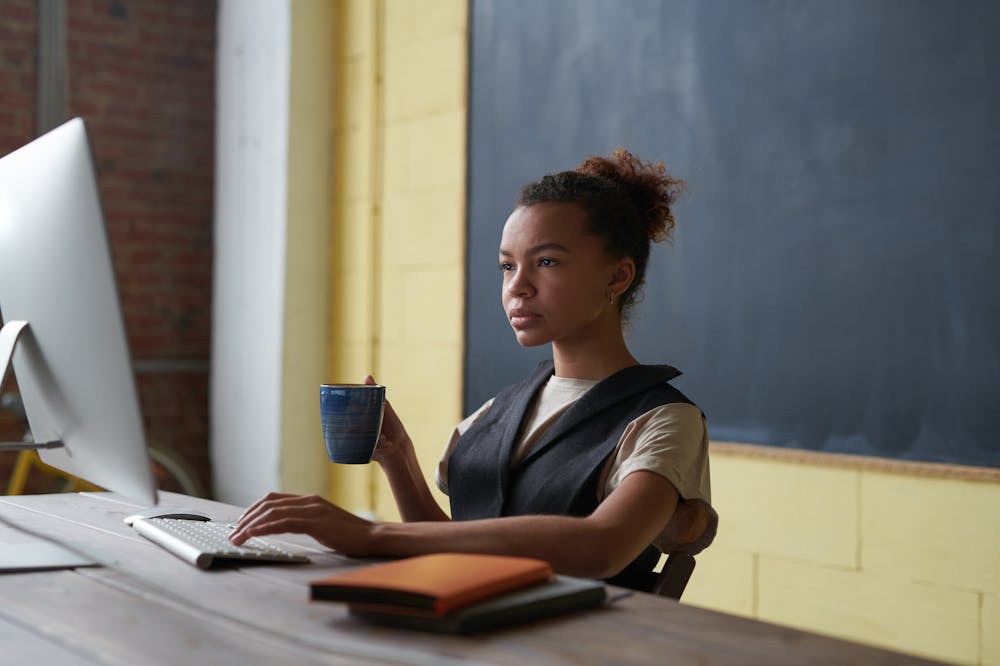 Woman-Holding-Mug-Looking-At Computer