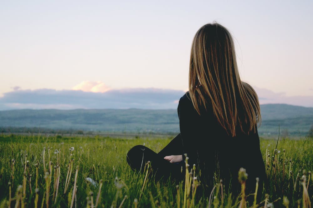 Woman-Sitting-Alone-Green-field