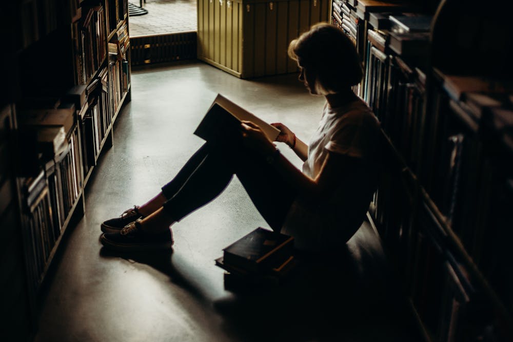 Woman-Sitting-On-Floor-Reading-Book