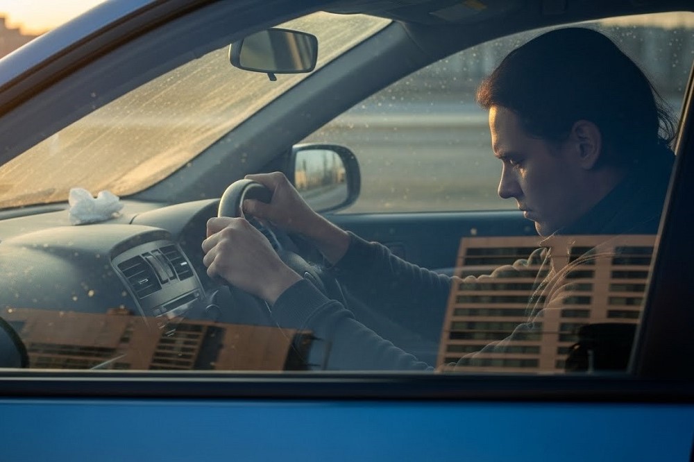 Man-Gripping-Steering-Wheel-Of-Car