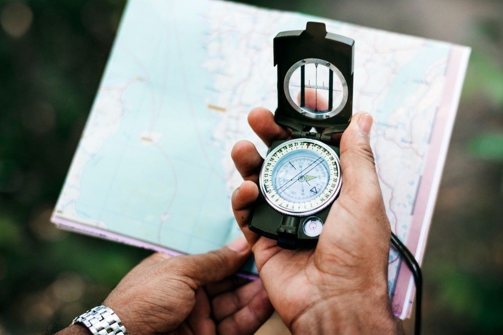 Man-Holding-Map-And-Compass