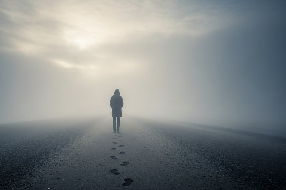 Solitary-Figure-Standing-On-Foggy-Shoreline