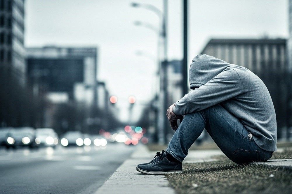 Man-sitting-alone-on-a-curb