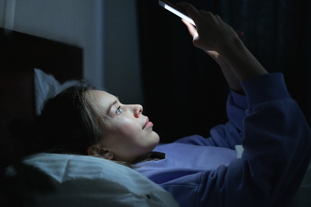 Doomscrolling-woman-using-smartphone-lying-in-bed